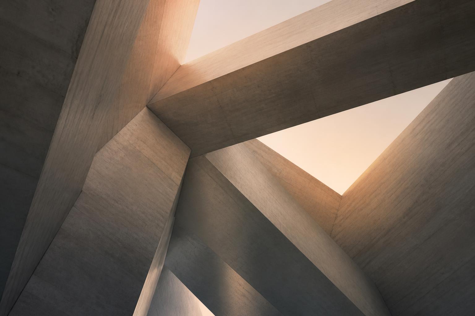 An architectural view up through intersecting concrete planes and beams meeting a soft dawn sky.